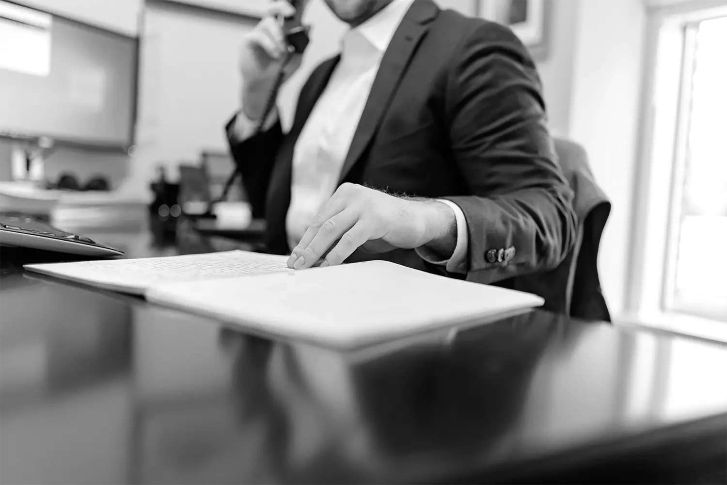 Profesional hablando por teléfono mientras revisa documentación